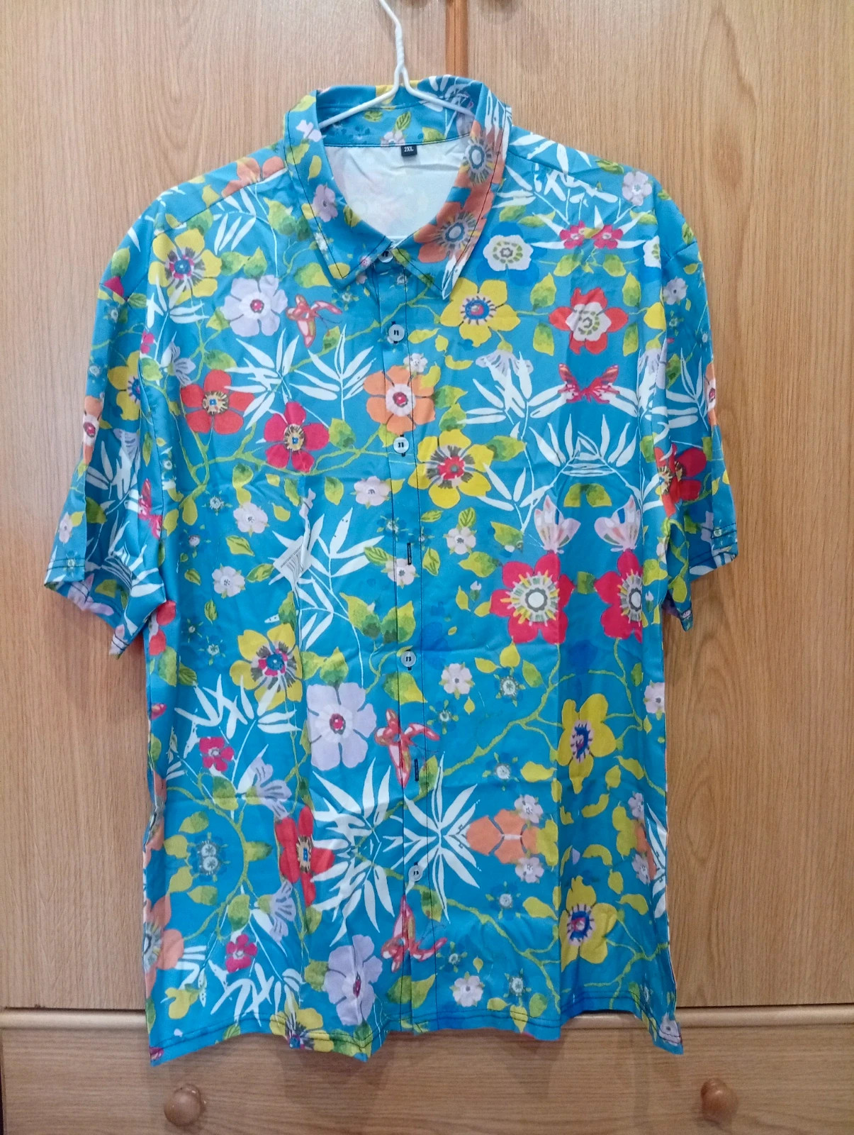 Bright and stylish blue shirt with a colorful floral print. Size L. – taille L