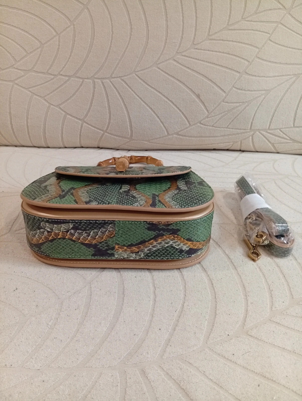 Stylish handbag with green snake-print design Bamboo handle and closure for a unique touch 2