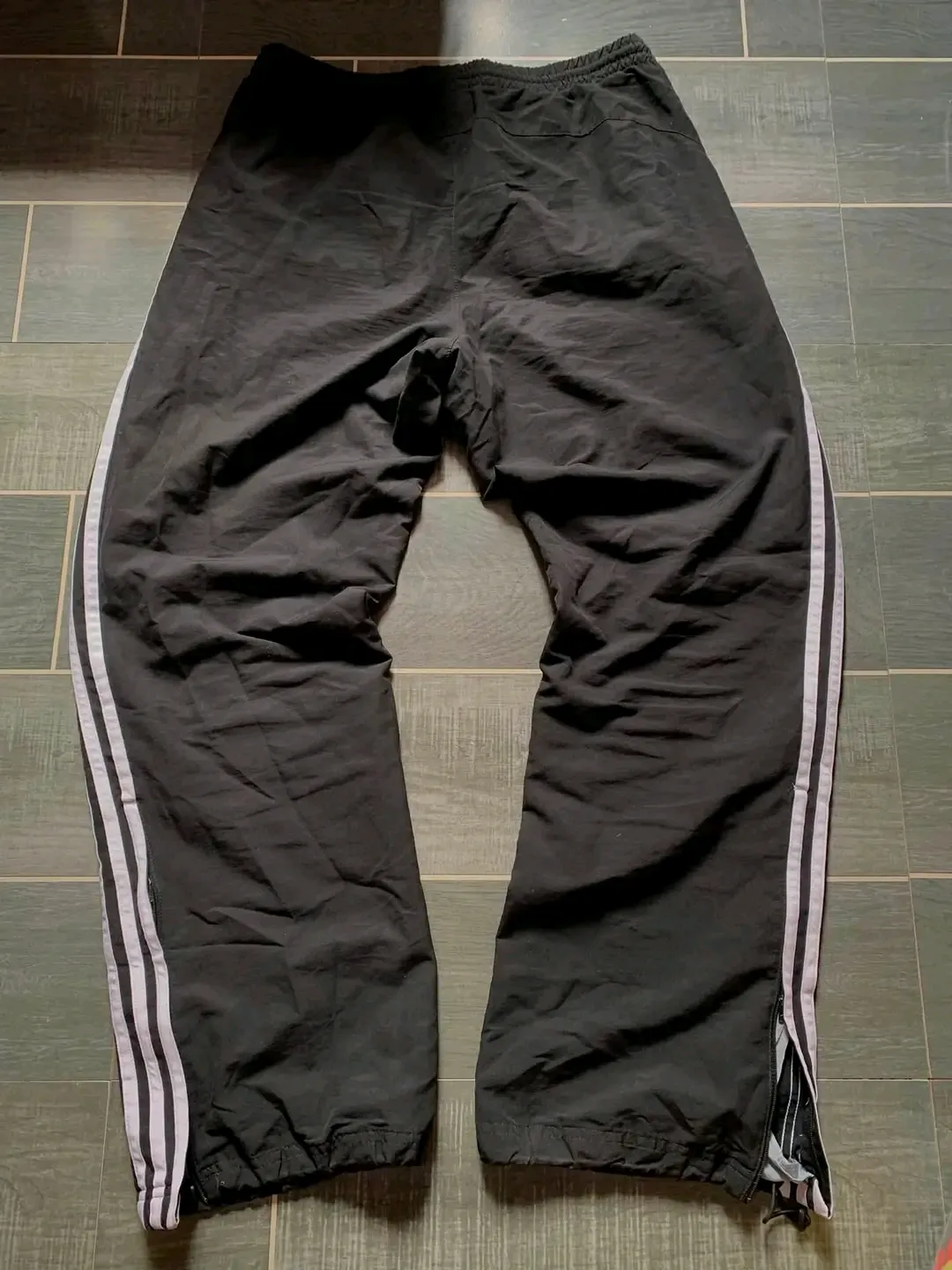 Black track pants with white stripes