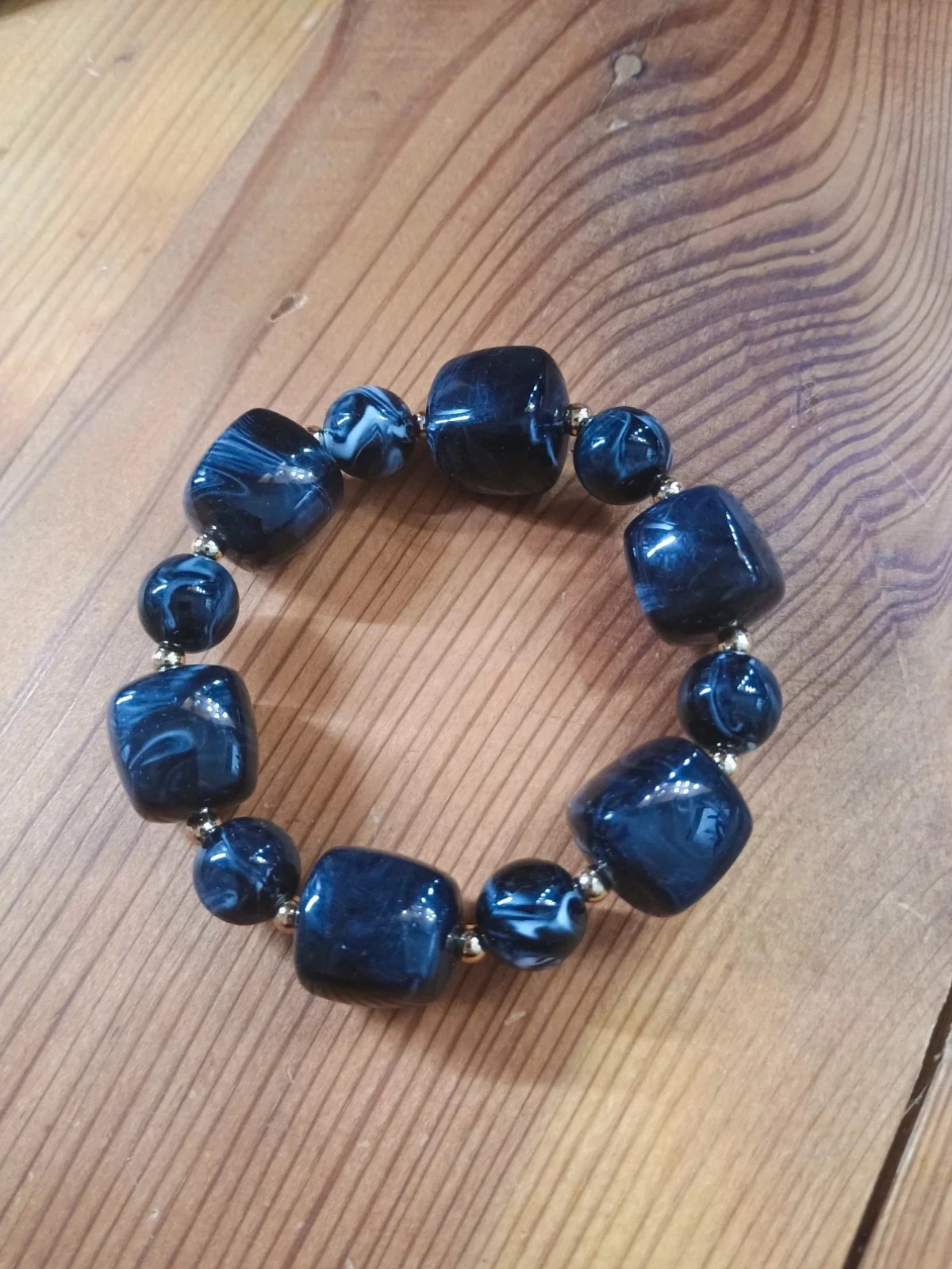 Pulsera Elástica de Cuentas negras Marmoleadas y Detalles Dorados