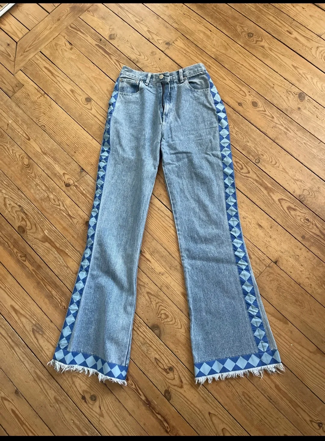 Jean bleu coupe flare avec détails à carreaux