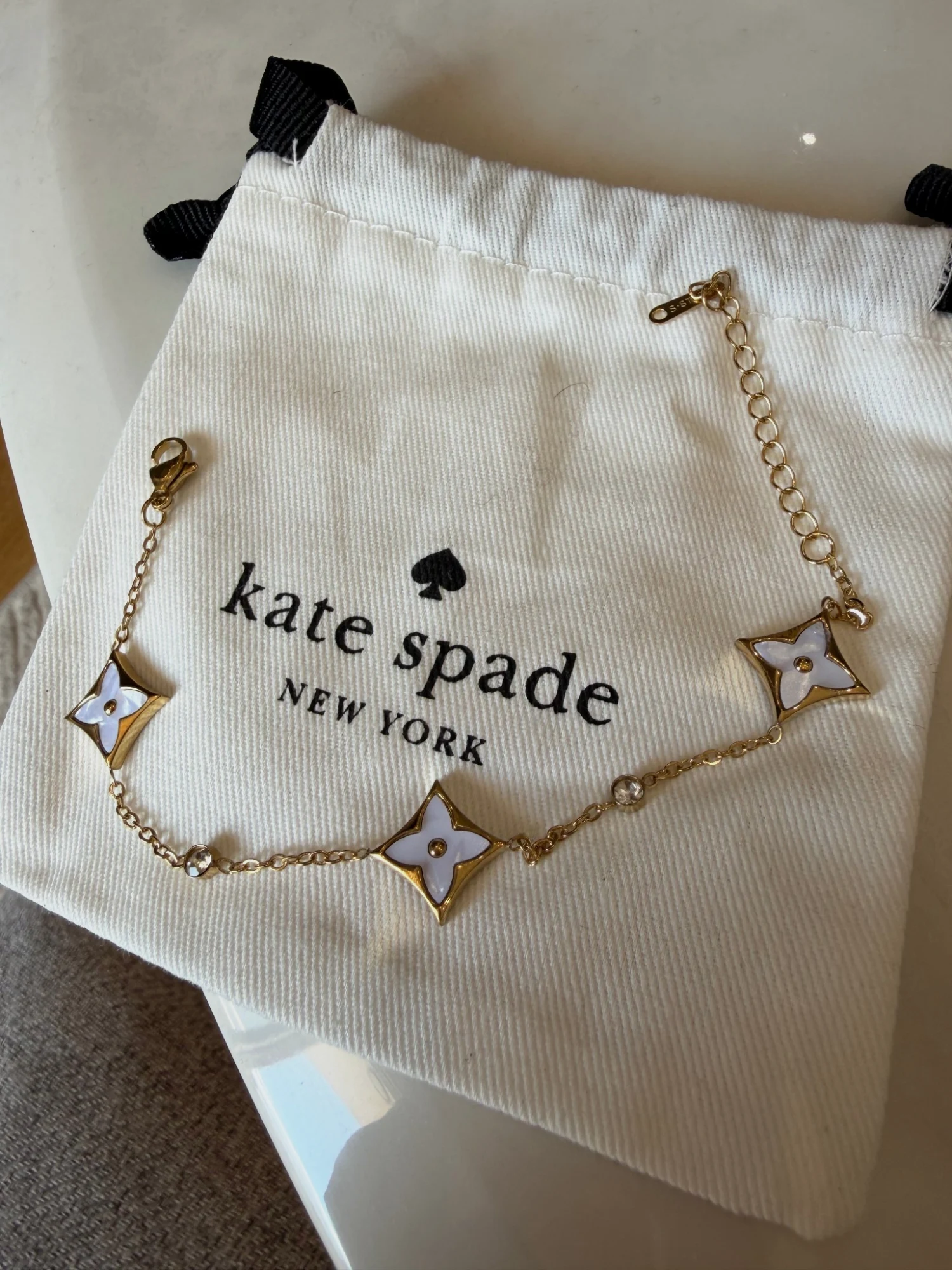 Bracelet dorée Kate Spade avec motifs trèfles