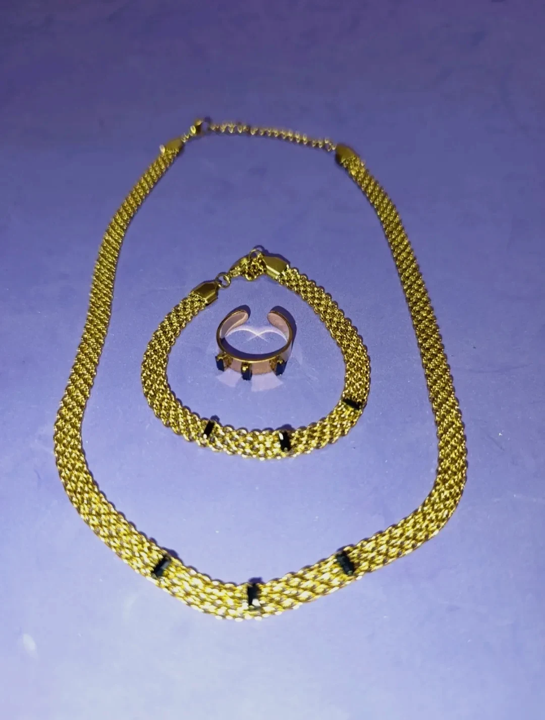 Conjunto acero dorado y piedras oscuras