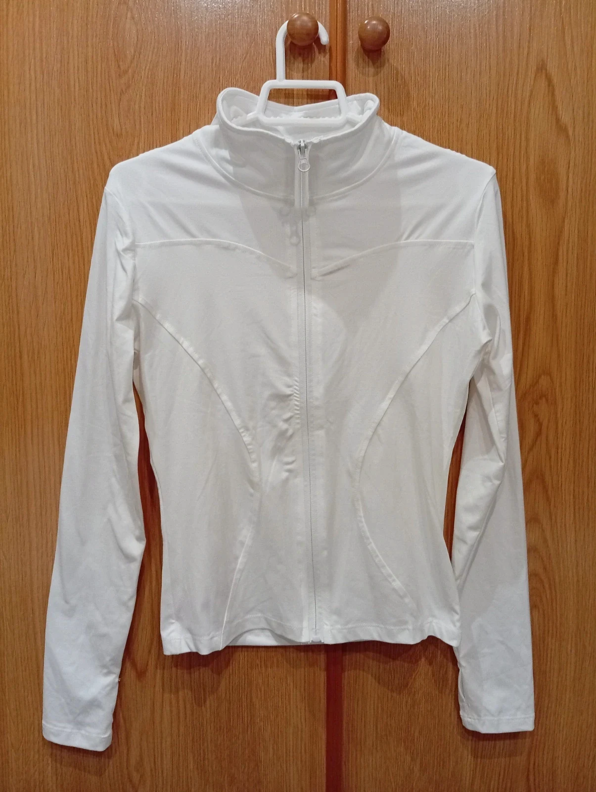 White long-sleeve sports jacket with a fitted design, full zip fastening