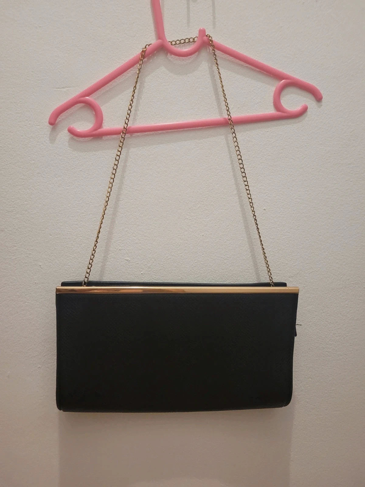 Bolso de mano negro con detalles dorados y cadena Atmosphere