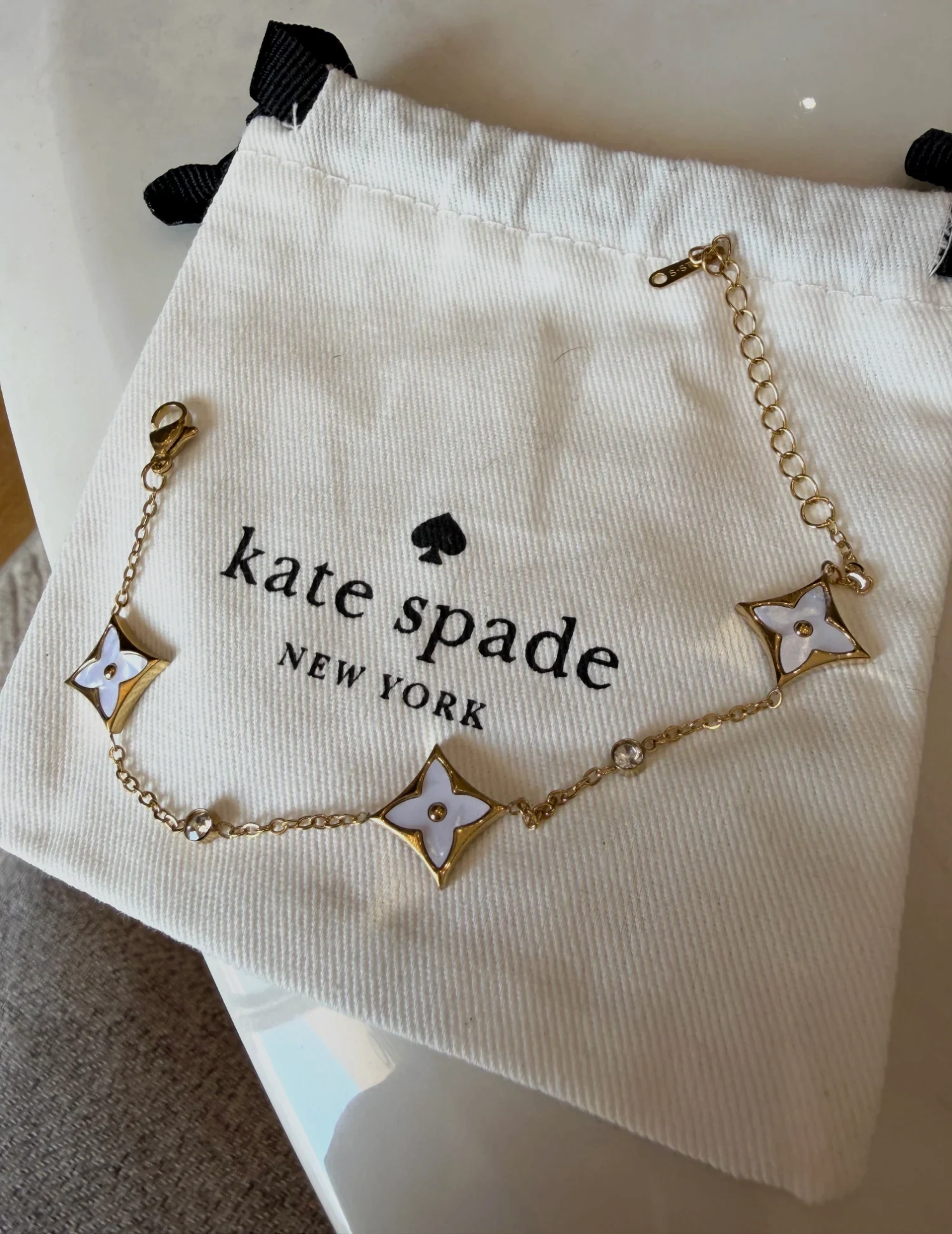 Bracelet en chaîne dorée Kate Spade avec motifs fleurs