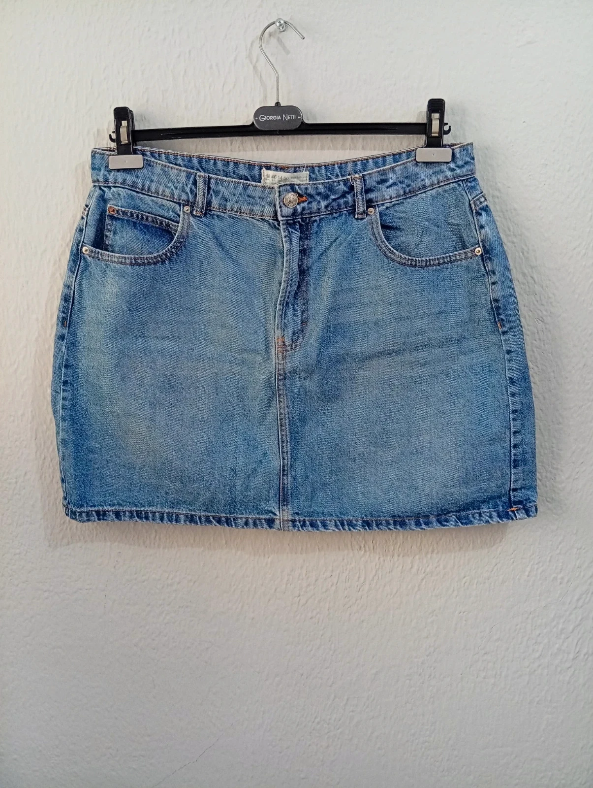 Falda denim en color azul claro, de corte recto y estilo casual.