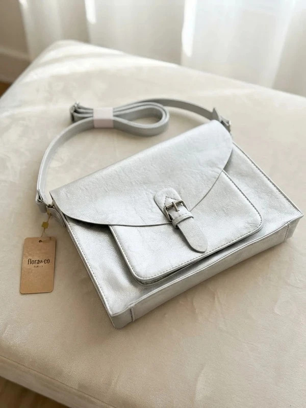 Bolso bandolera de la marca Flora & Co en un precioso tono plateado con efecto metalizado
