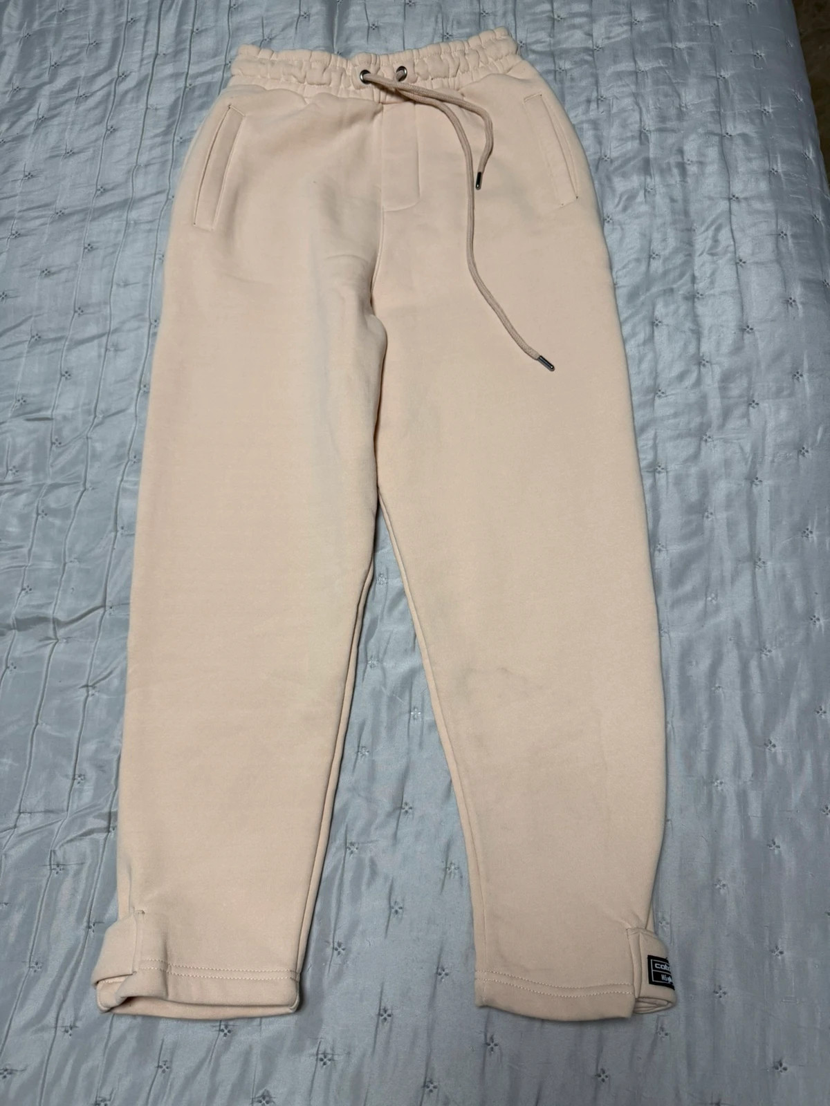 Pantalón de chándal en color beige / crema, de corte recto y tiro alto.