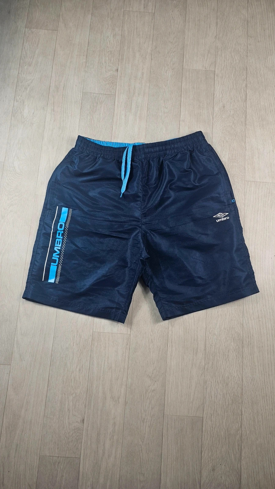 Short de sport Umbro bleu homme L défaut