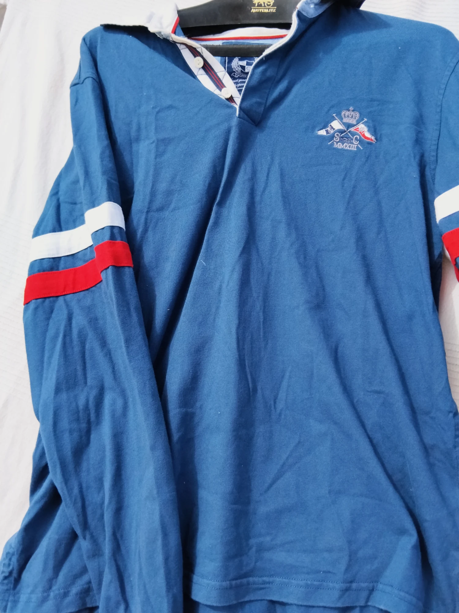 Polo de manga larga azul con detalles de franjas