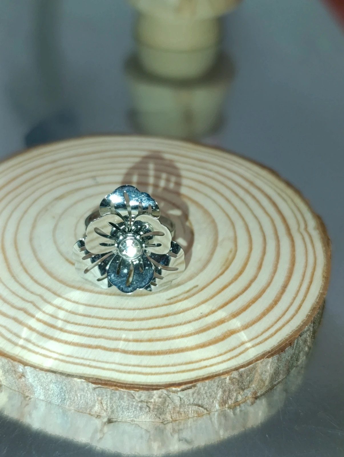 Anillo ajustable plateado y diseño floral con cristalito